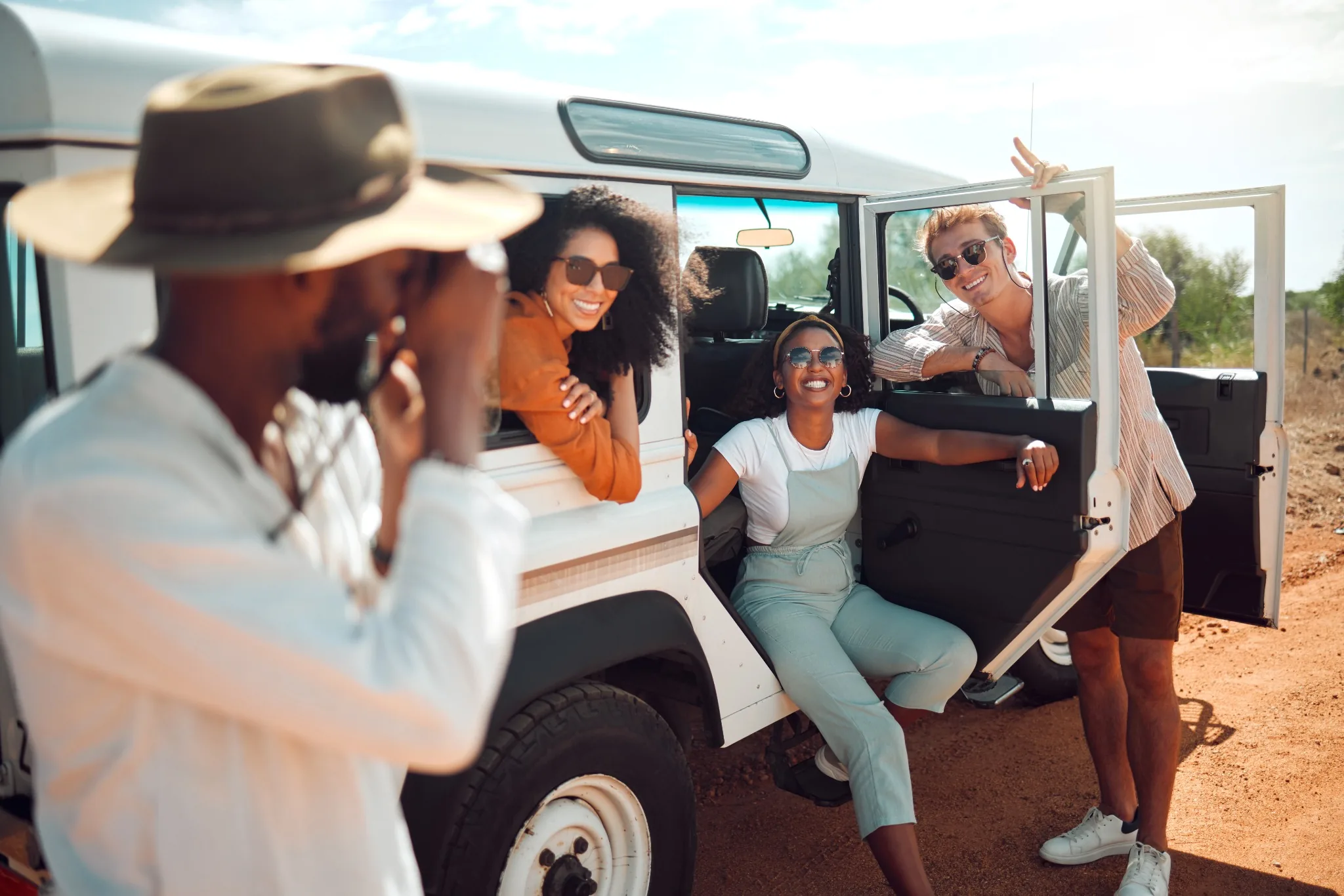 Guía fotografiando a un grupo de viajeros junto al vehículo del tour